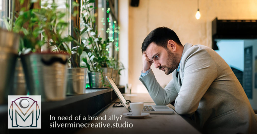 Man stares at a laptop, hating his branding. 